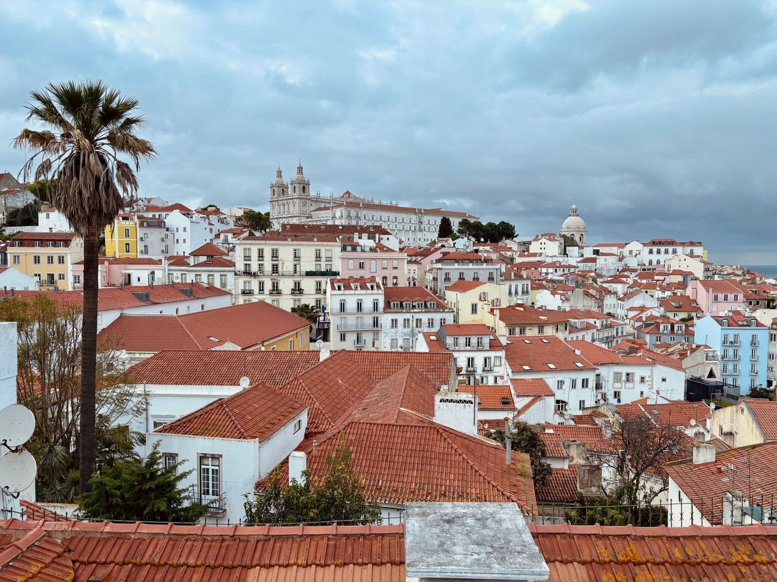 Alfama's red rooftops and the Tagus from a viewpoint above the old town