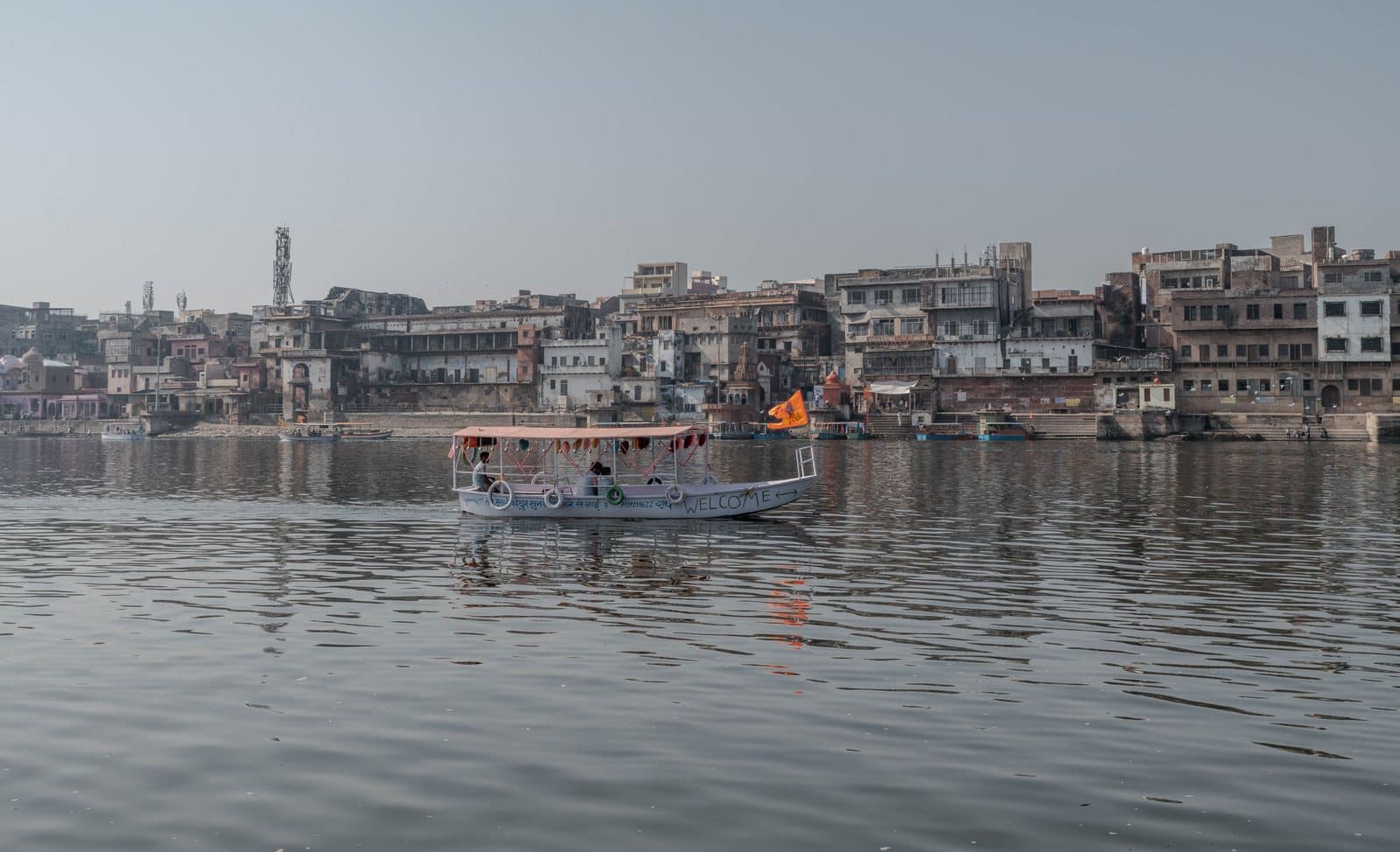 A boat on the Yamuna with Mathura's riverfront behind
