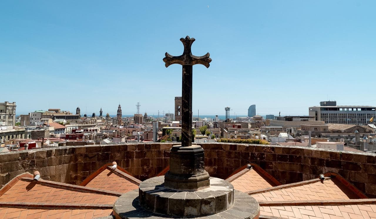Cruz en la terraza de la Catedral de Barcelona, con la ciudad al fondo