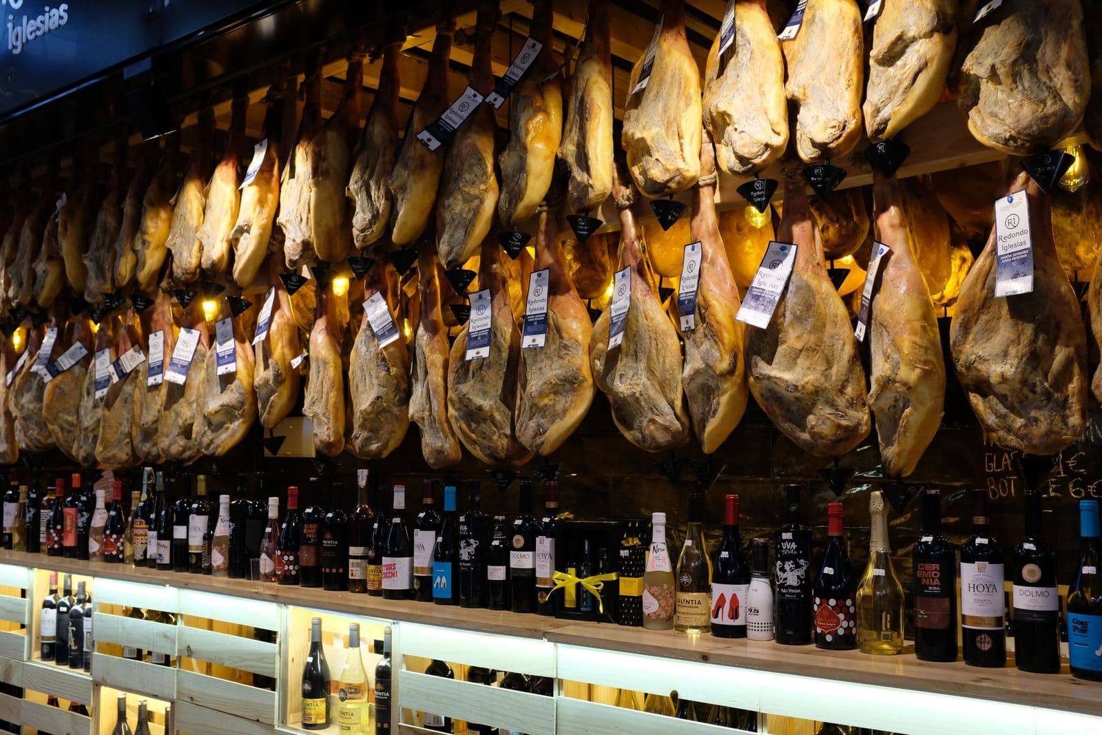Jamones colgados sobre un mostrador en un mercado de Barcelona