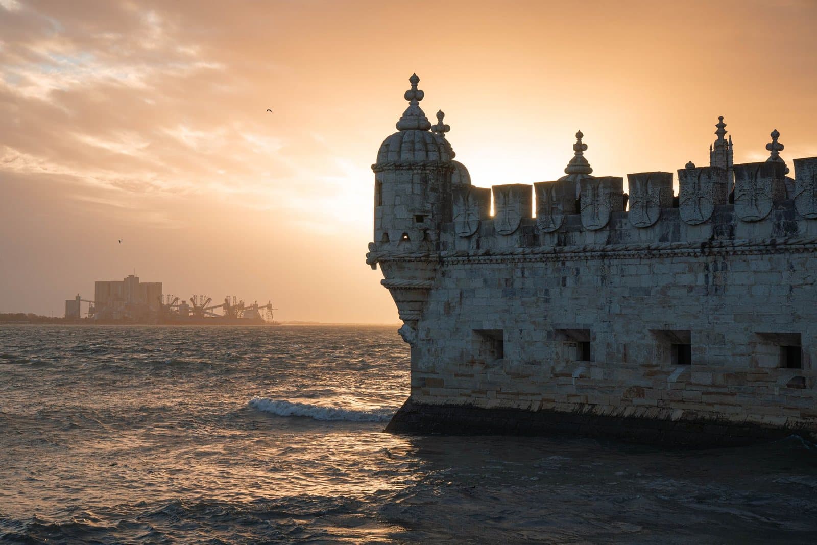 The bastion of Belém Tower against a sunset over the Tagus