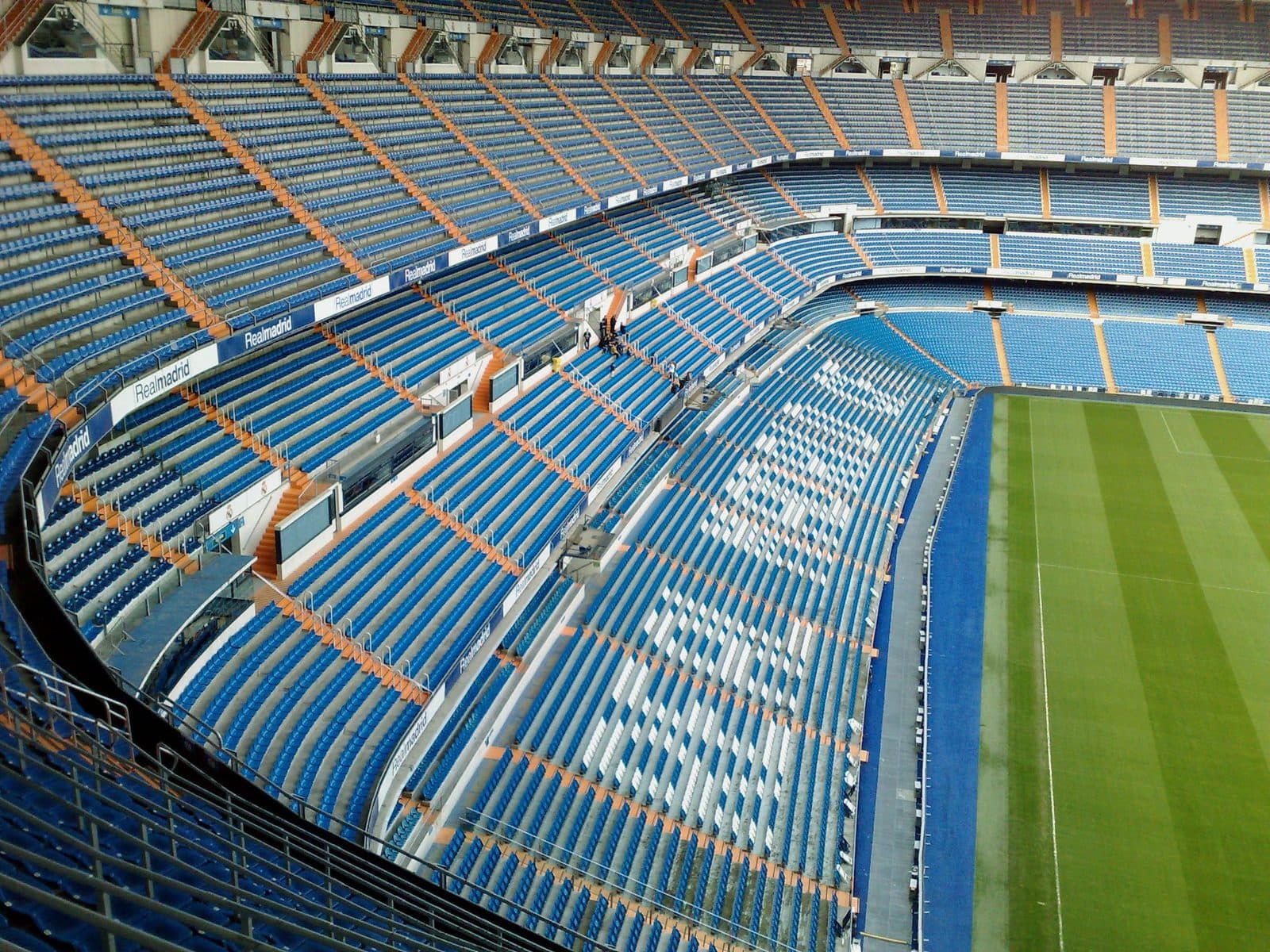 Leere blaue Tribünen des Santiago Bernabéu, die zum Spielfeld hin abfallen