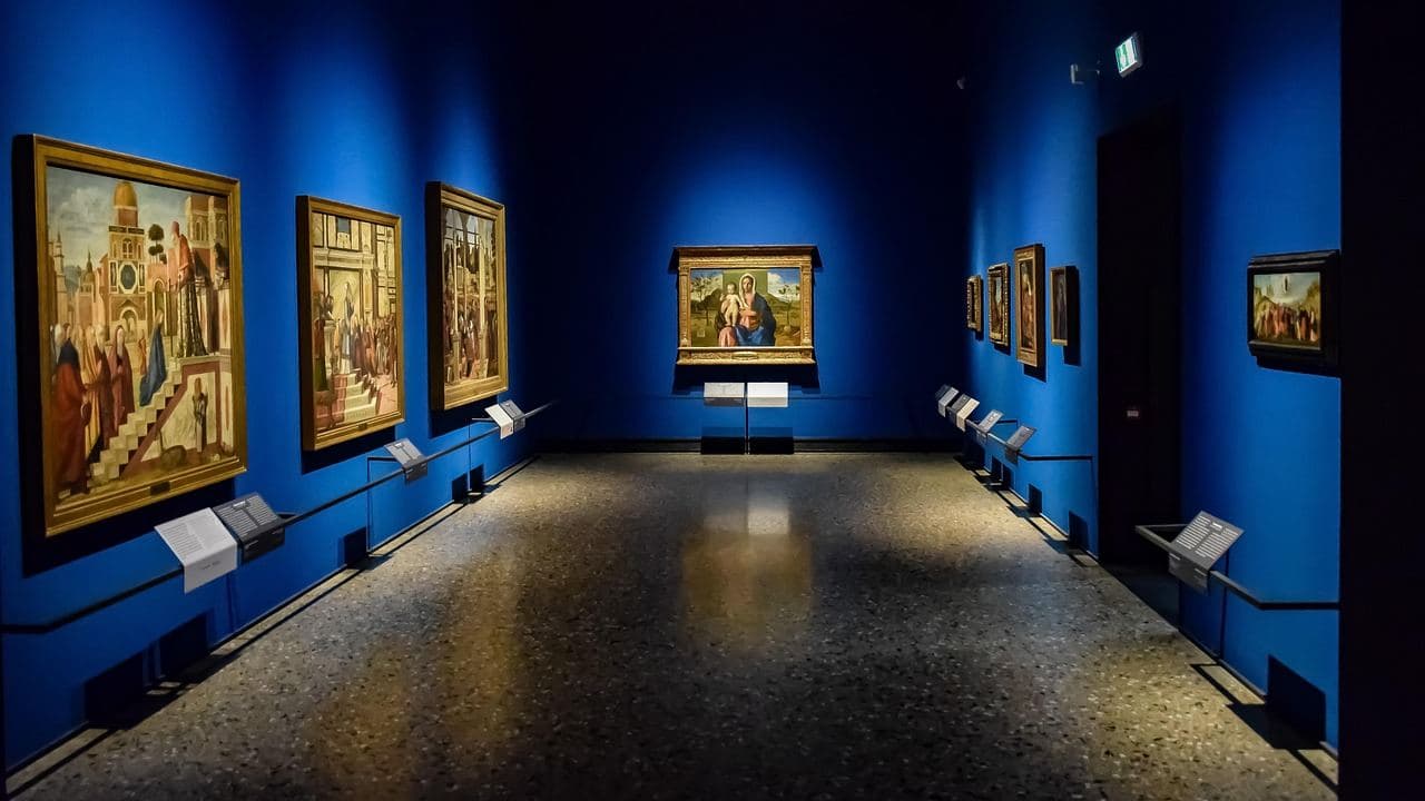 Blue-walled gallery room with Old Master paintings in the Pinacoteca di Brera