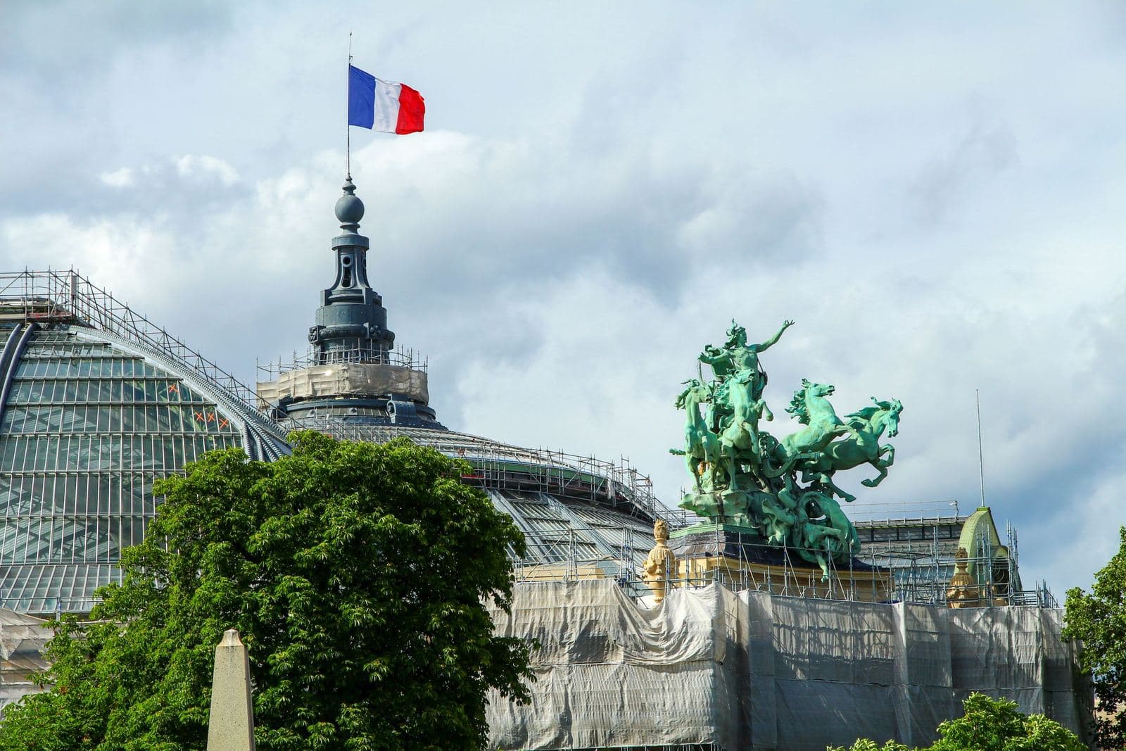 Dach des Grand Palais mit seiner bronzenen Quadriga und einer französischen Flagge