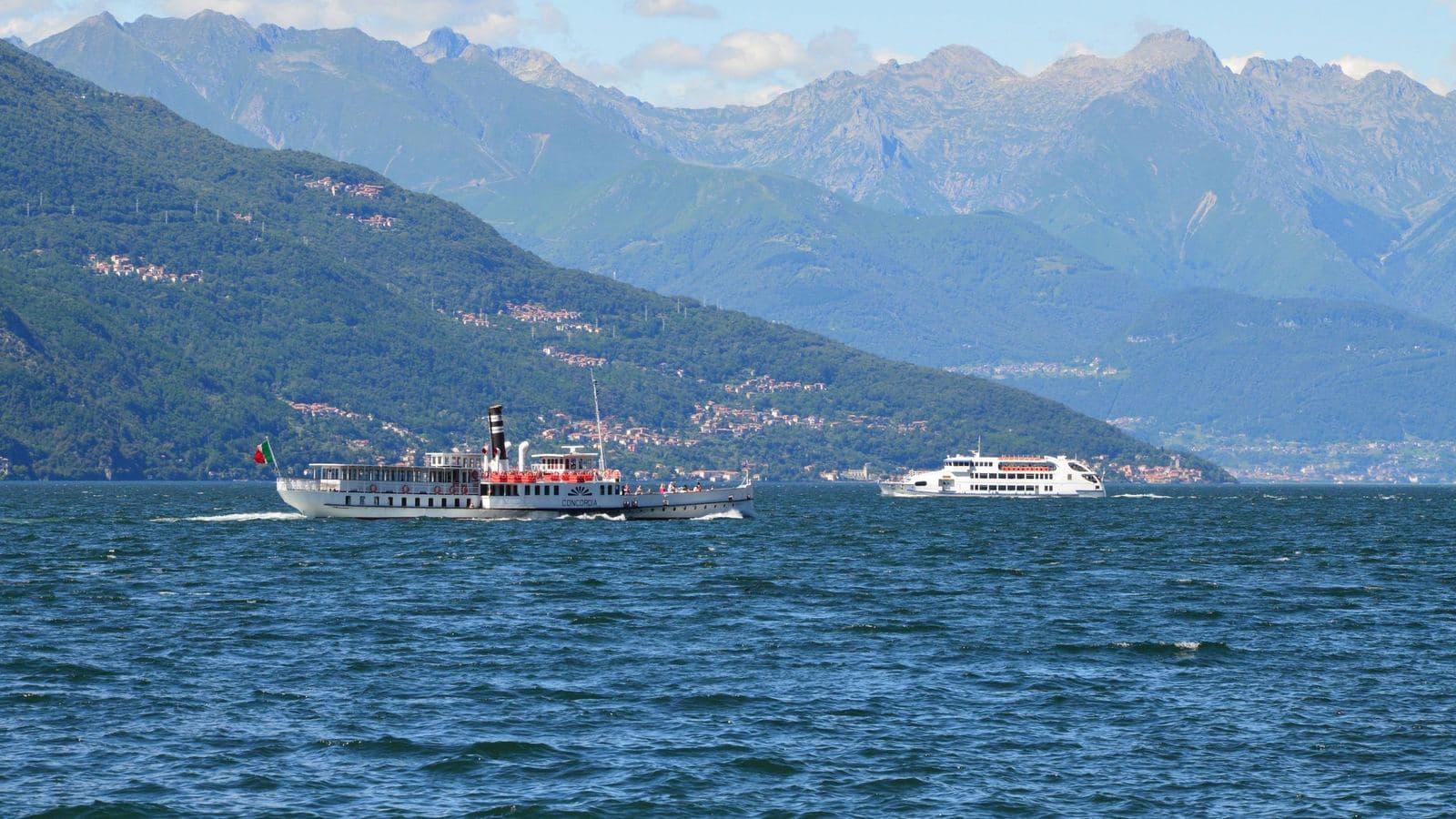 Boats crossing Lake Como with mountains behind