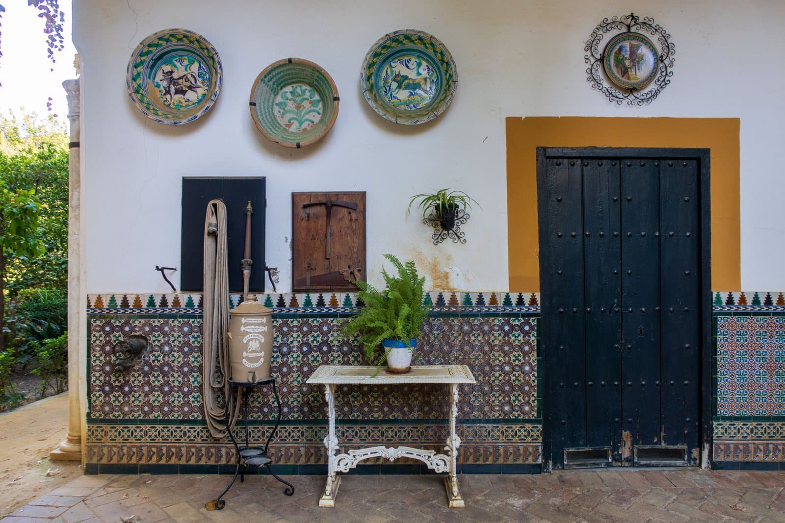 Ein andalusischer Patio in Sevilla mit bemalten Fliesen und Topfpflanzen