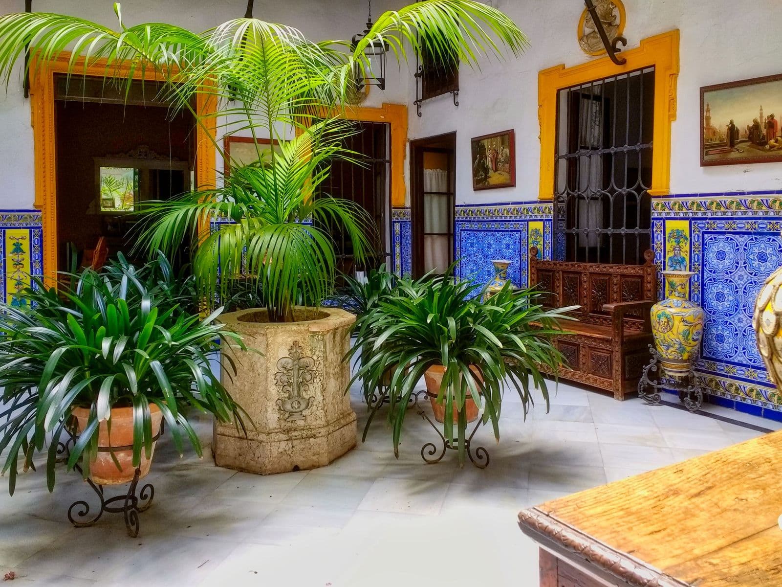 Ein Patio in Sevilla mit traditionellen Fliesen und Grün