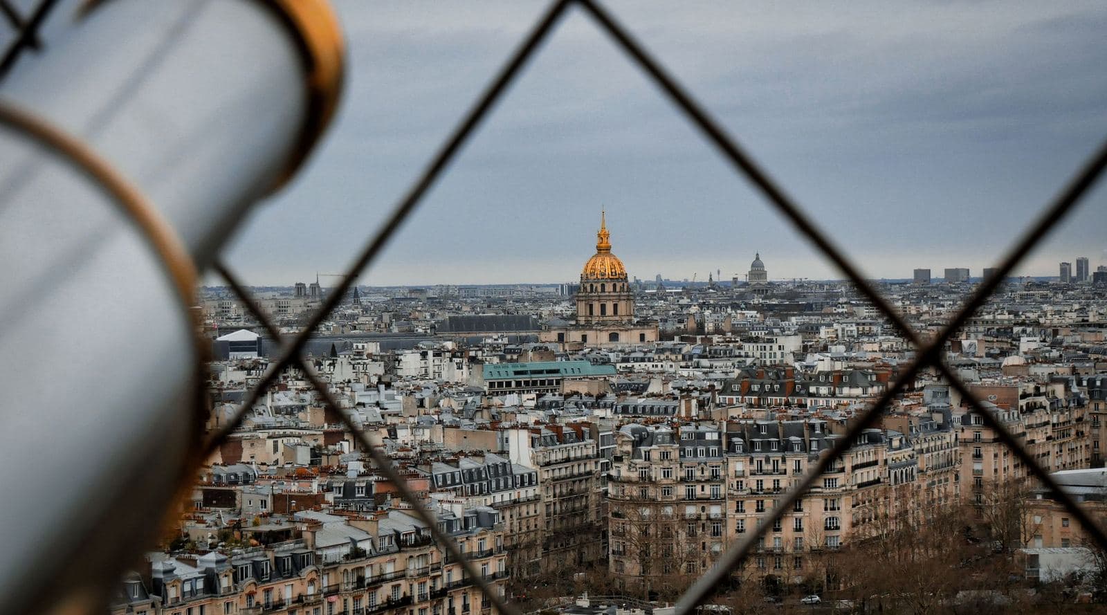 Los tejados de París y la cúpula de Los Inválidos vistos a través del entramado de la Torre Eiffel