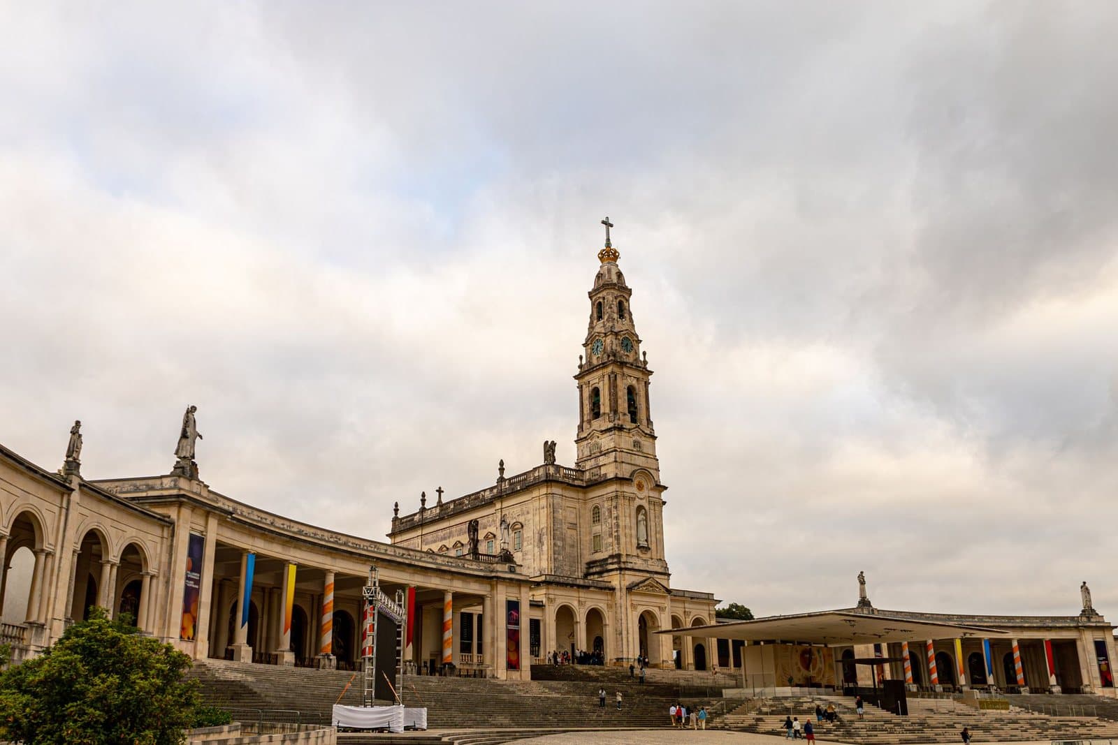 The basilica and colonnade of the Sanctuary of Fátima under a cloudy sky
