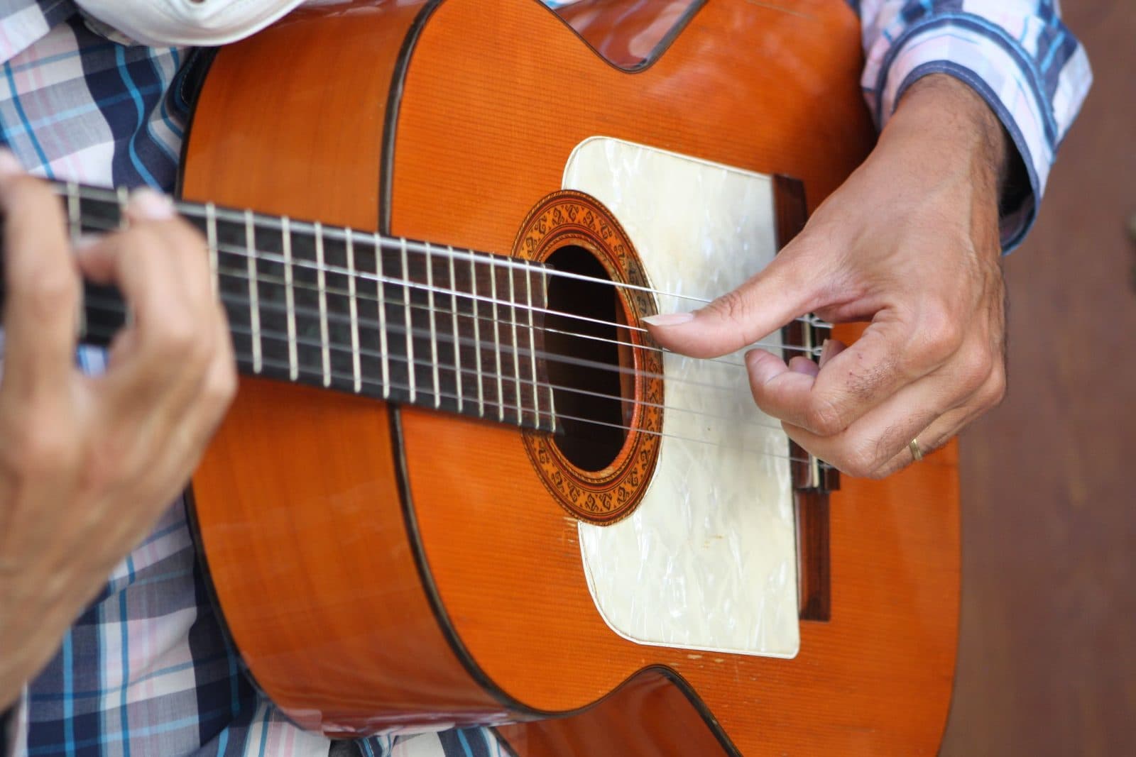Primo piano delle mani di un chitarrista su una chitarra flamenca