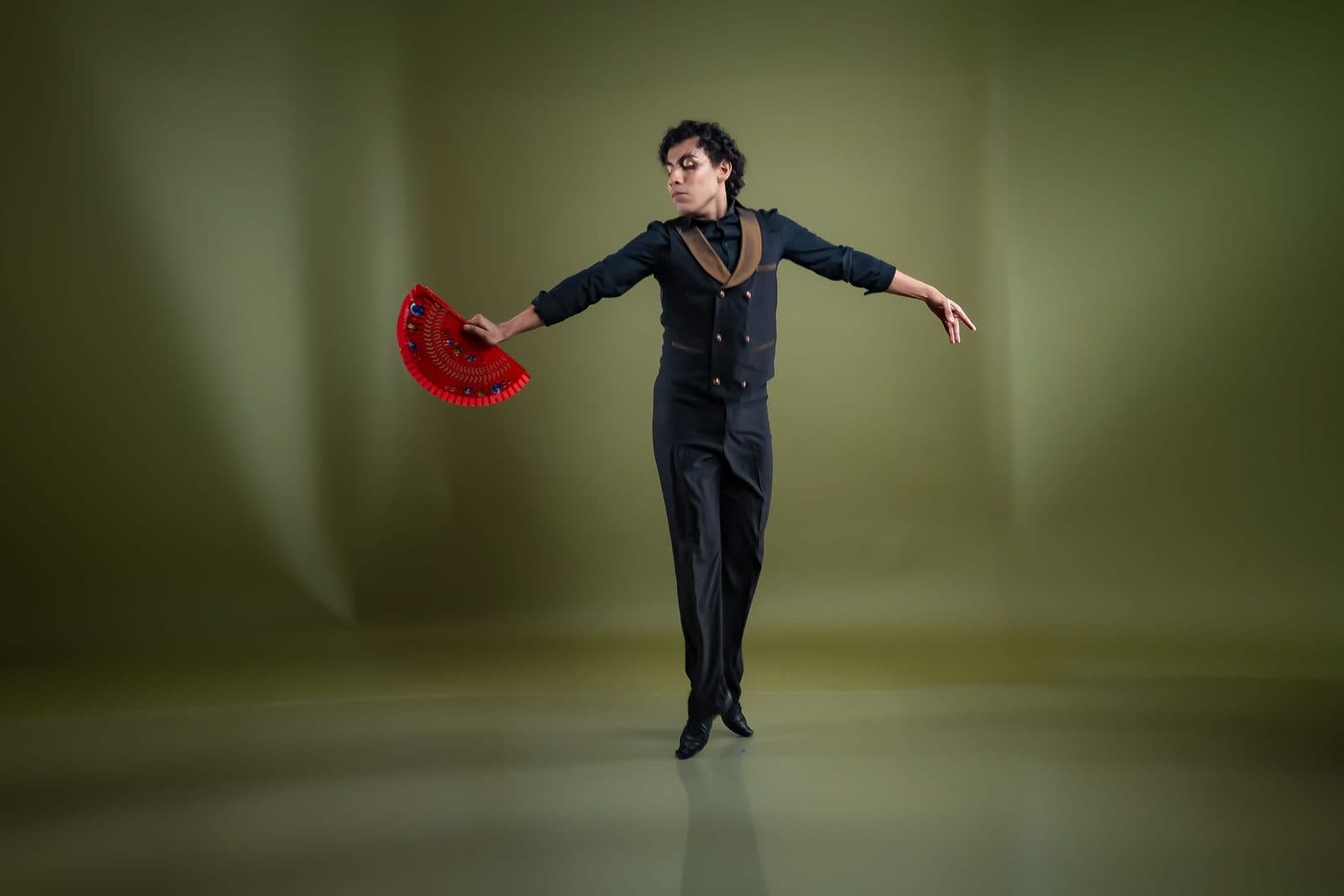 Ballerino di flamenco a metà di un passo con un ventaglio rosso