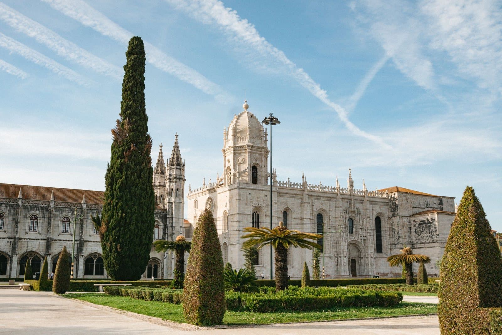 The long limestone façade of the Jerónimos Monastery behind its gardens
