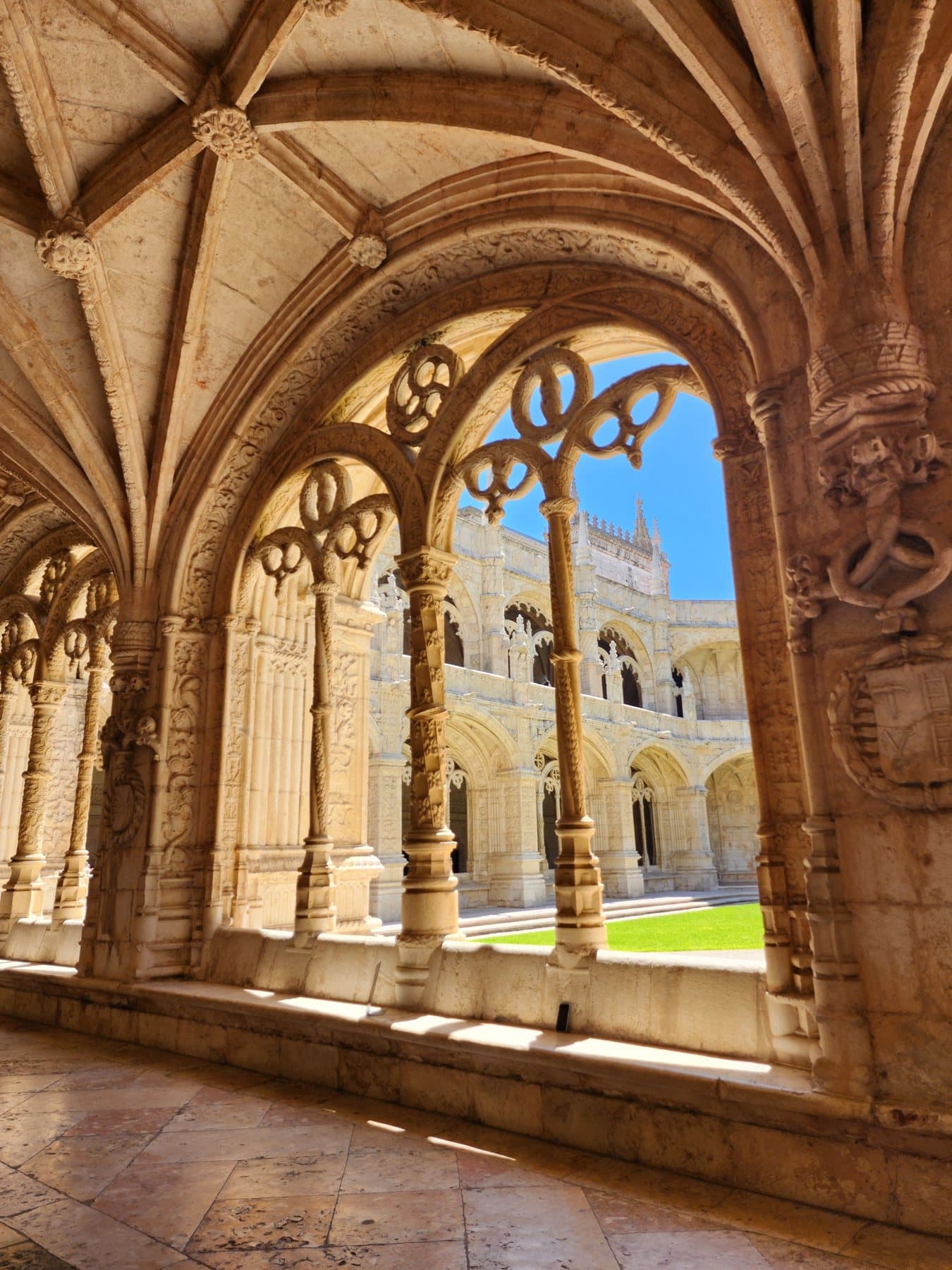 Carved Manueline arches in the Jerónimos cloister, open to the garden