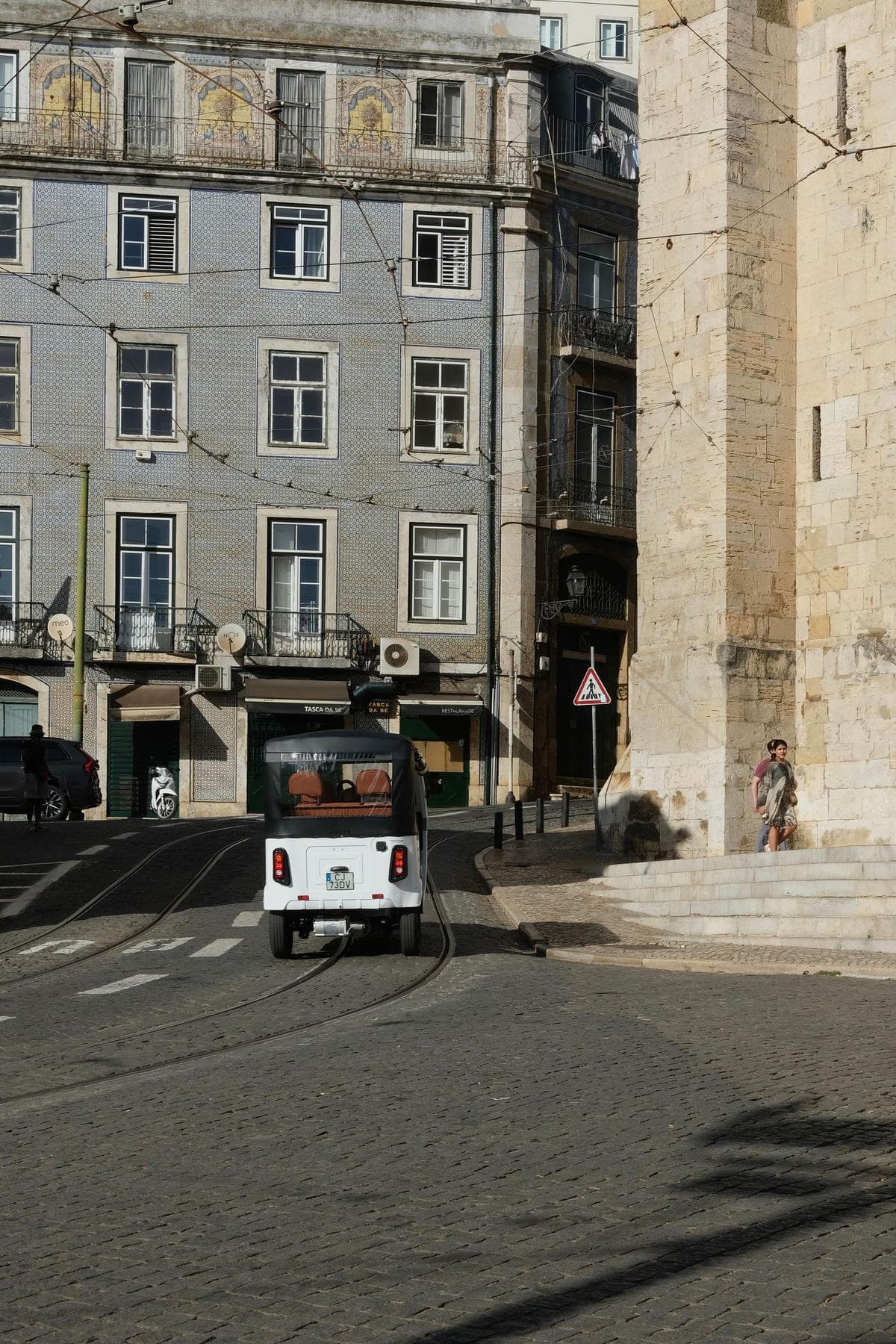 A tuk-tuk on a cobbled street in Lisbon's old town