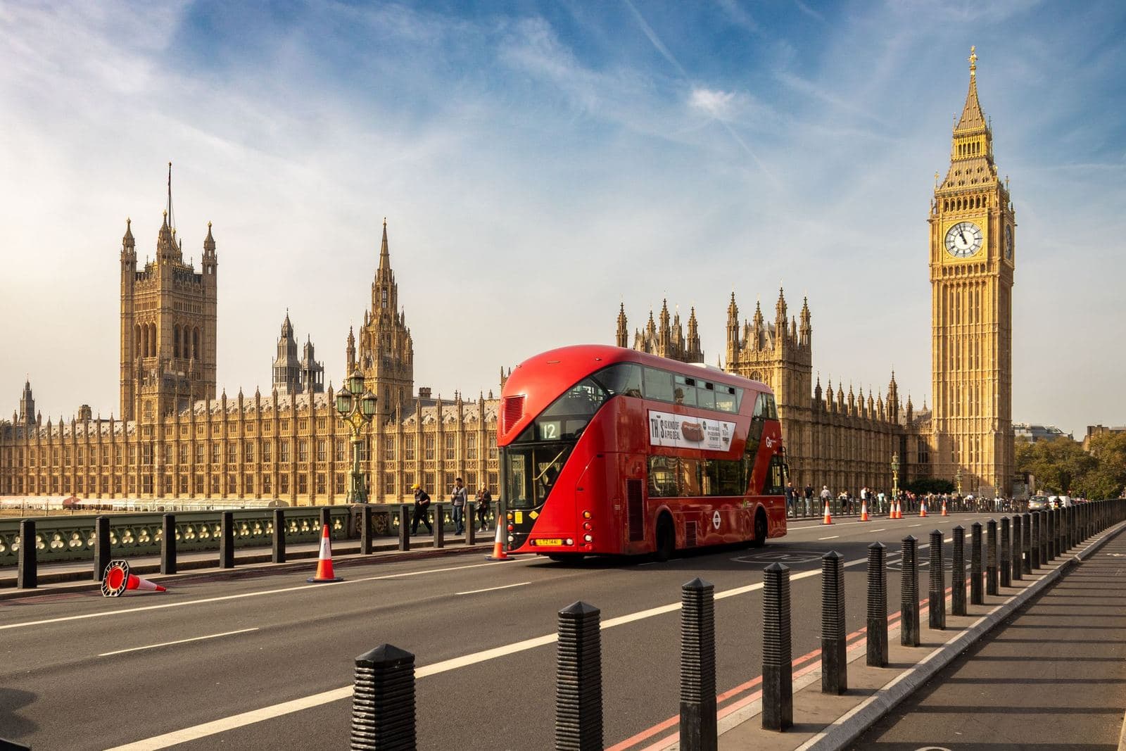 Red double-decker bus passing the Houses of Parliament and Elizabeth Tower
