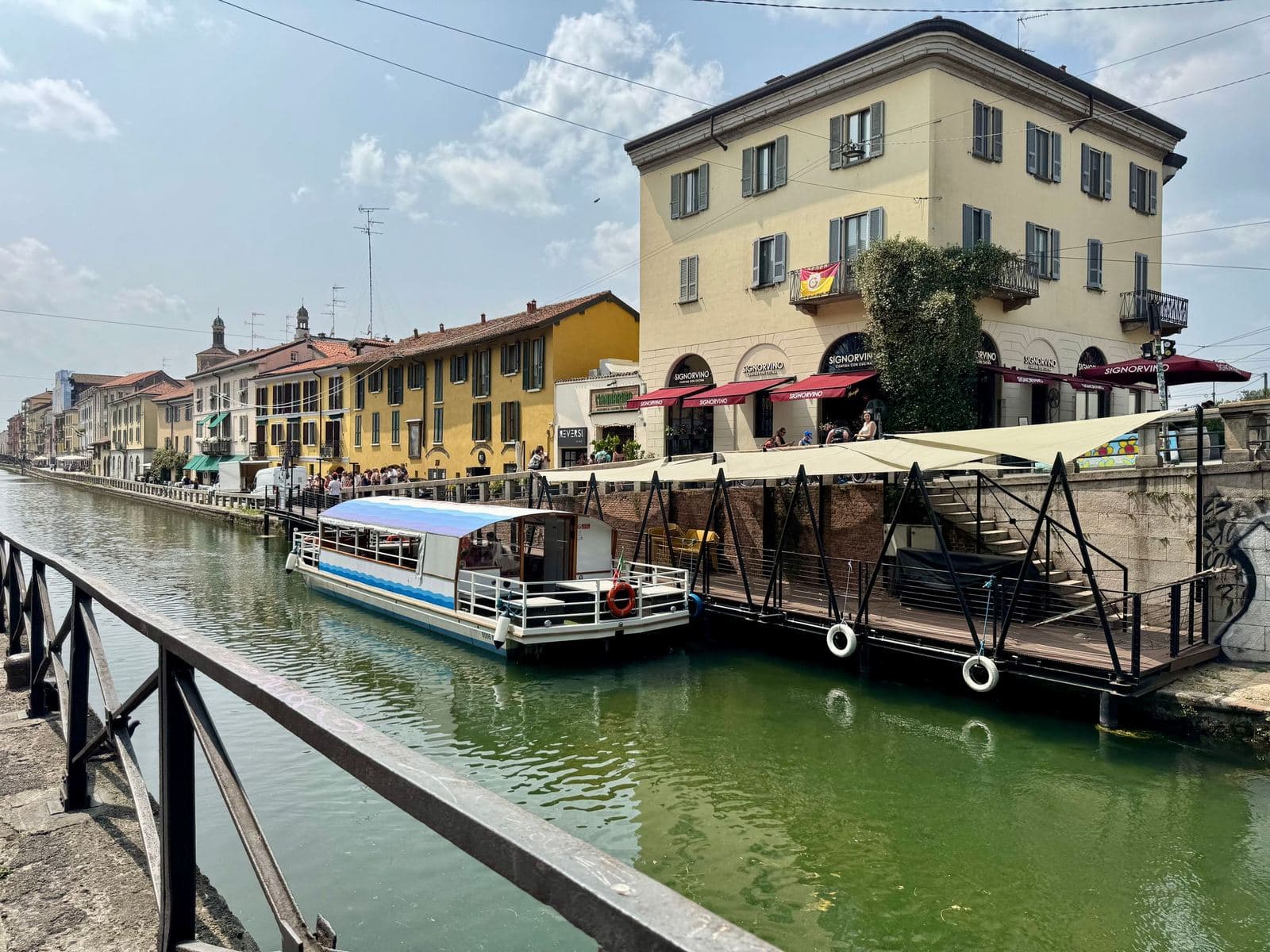 Naviglio Grande canal in Milan with coloured houses and a moored boat