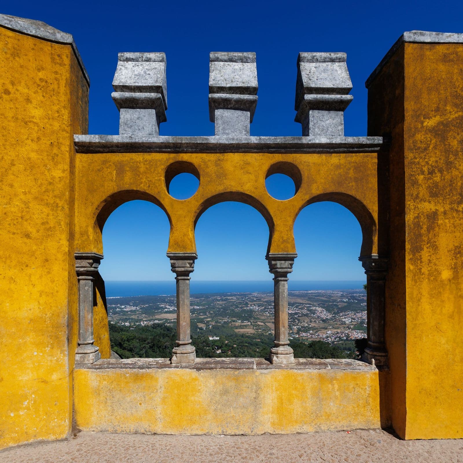 A Moorish-style window at Pena Palace framing the view over the hills