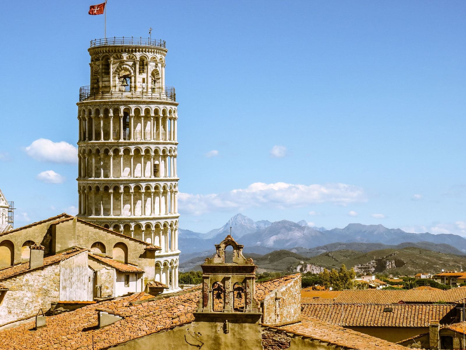 Leaning Tower above the Pisa rooftops with hills behind