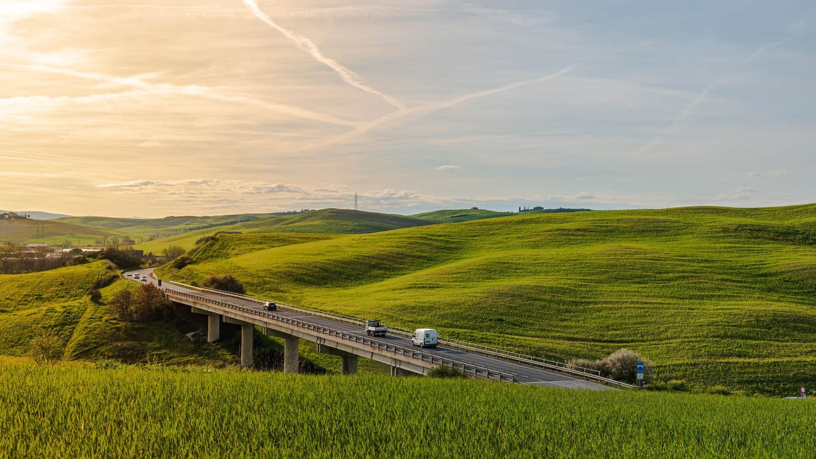 Una strada che si snoda tra le verdi colline della Toscana