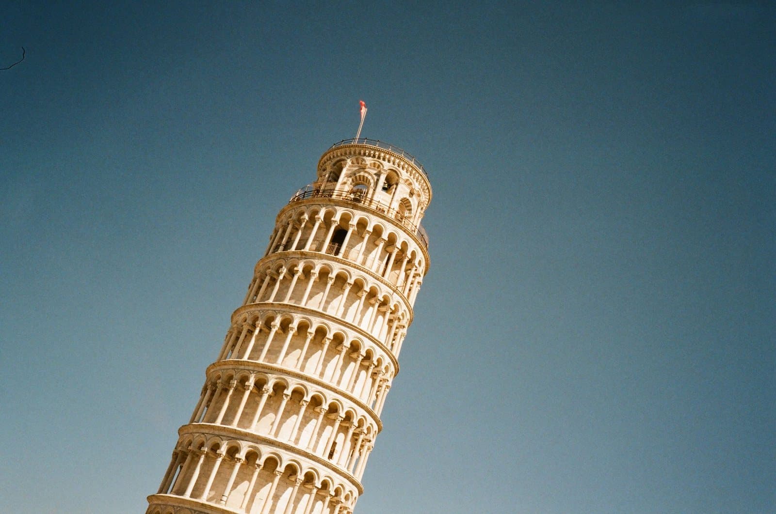 La sommità della Torre pendente di Pisa contro il cielo azzurro