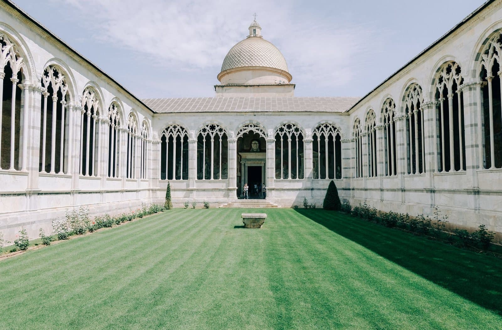The cloister lawn of the Camposanto Monumentale, with the Cathedral's dome beyond