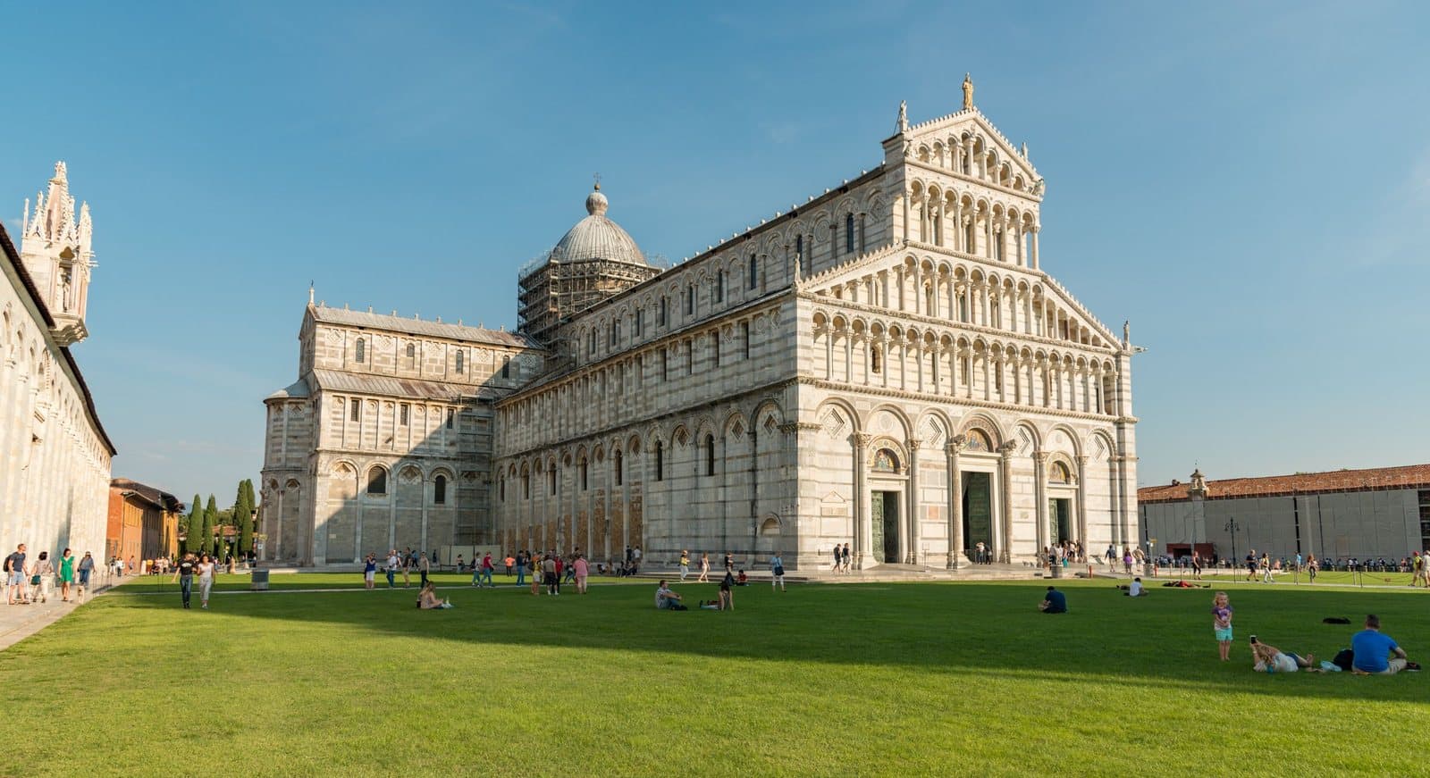 Pisa Cathedral, with visitors on the lawn in front