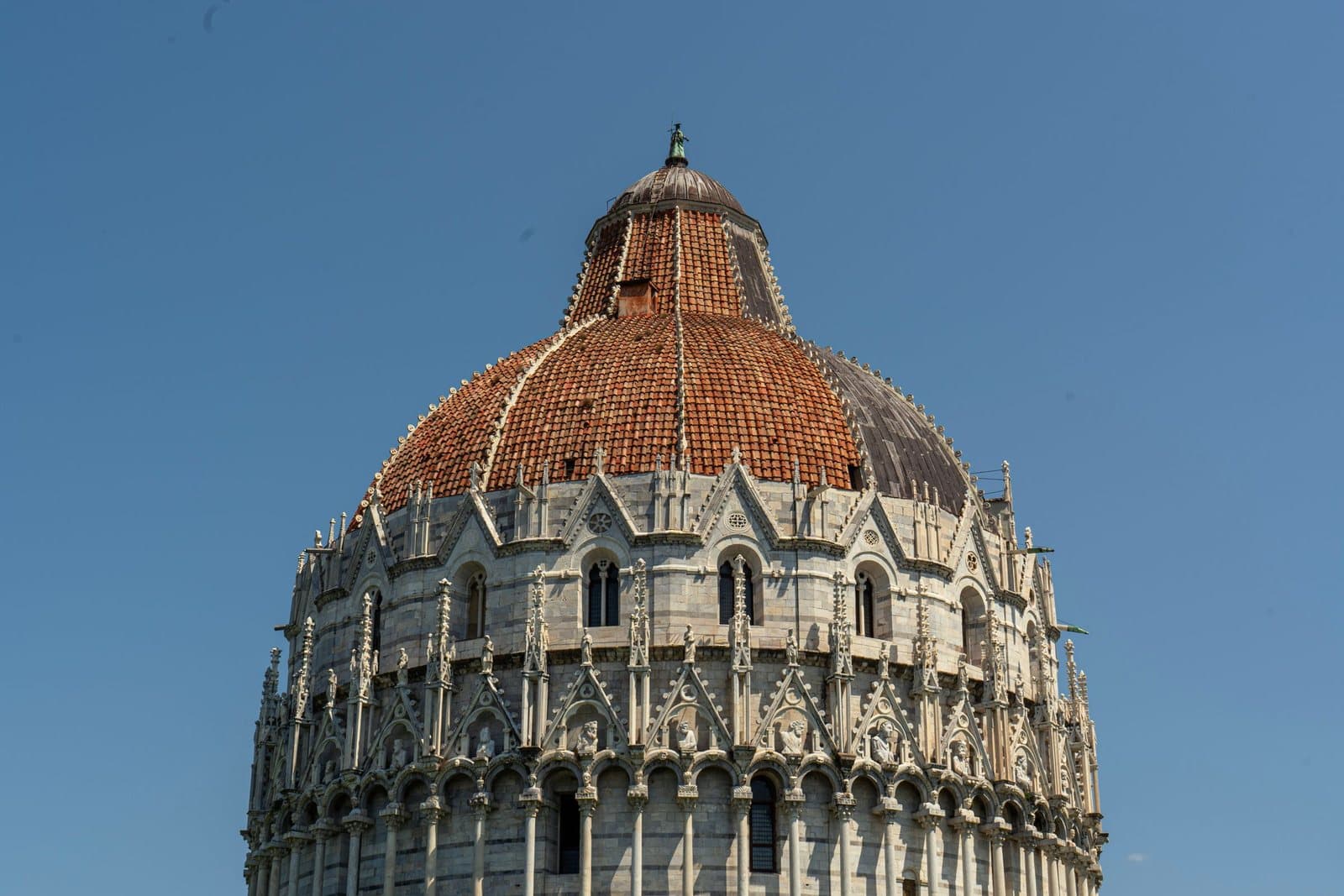The dome of Pisa Baptistery against a blue sky