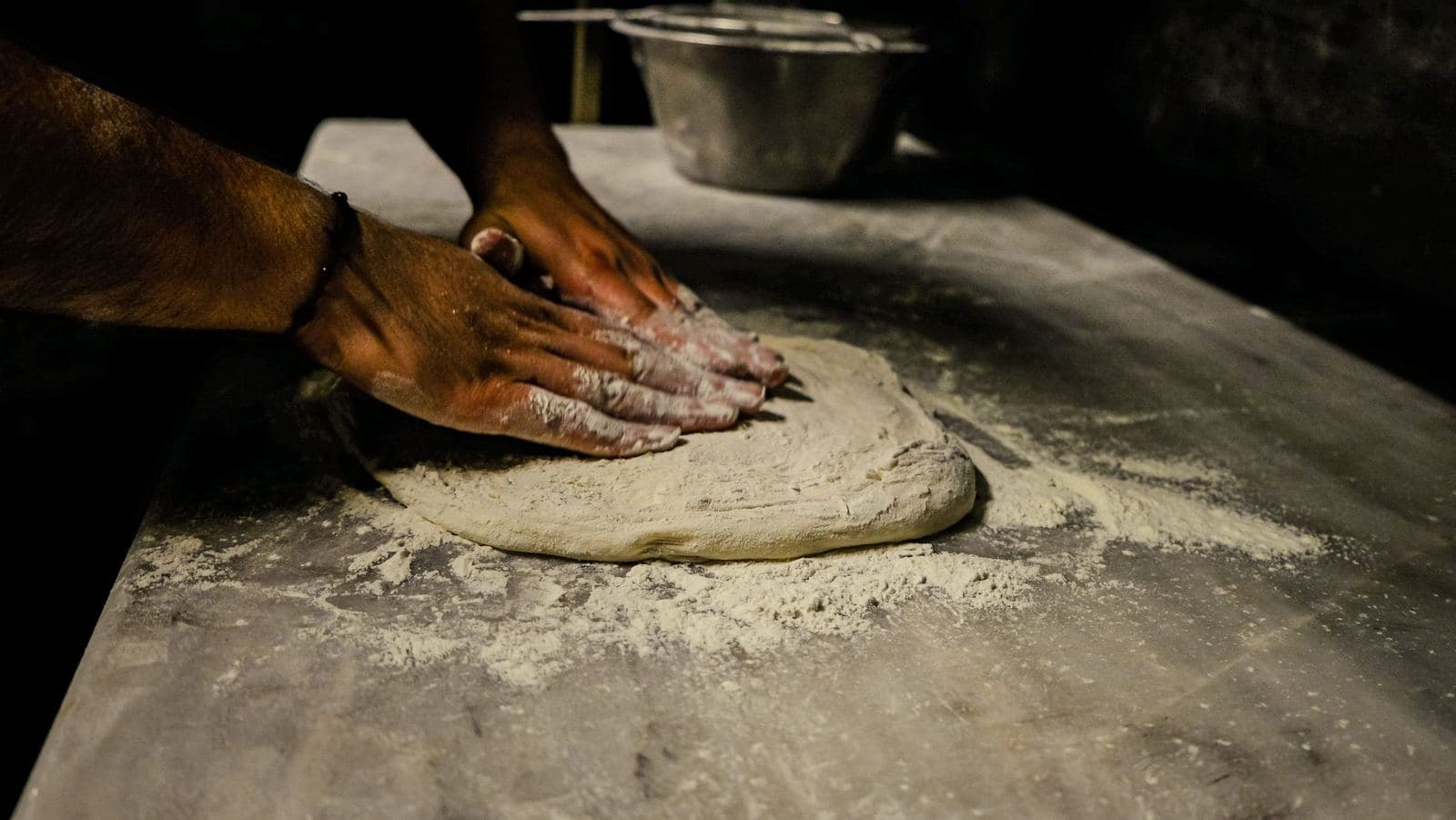 Kneading pizza dough on a floured table