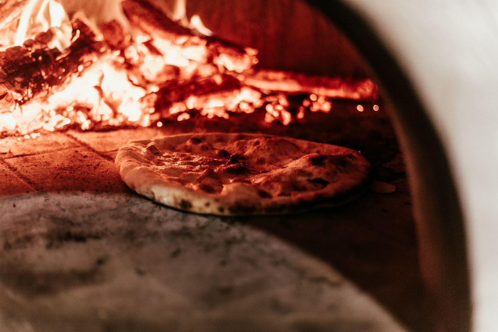 Pizza baking in a wood-fired oven