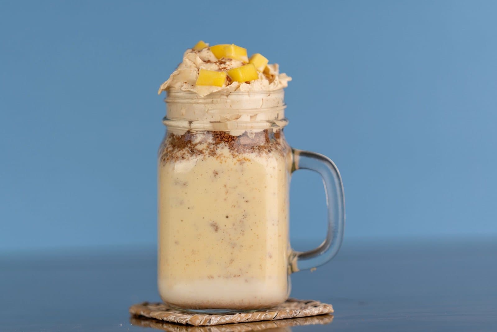 A thick mango milkshake topped with cream and mango pieces