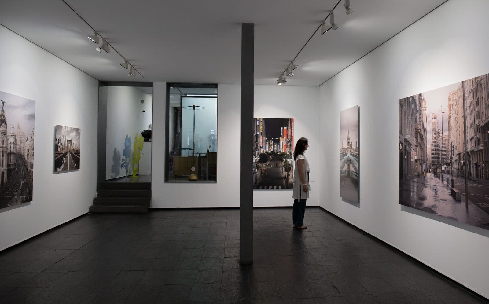 Besucher vor Stadtansichten in einer Madrider Kunstgalerie