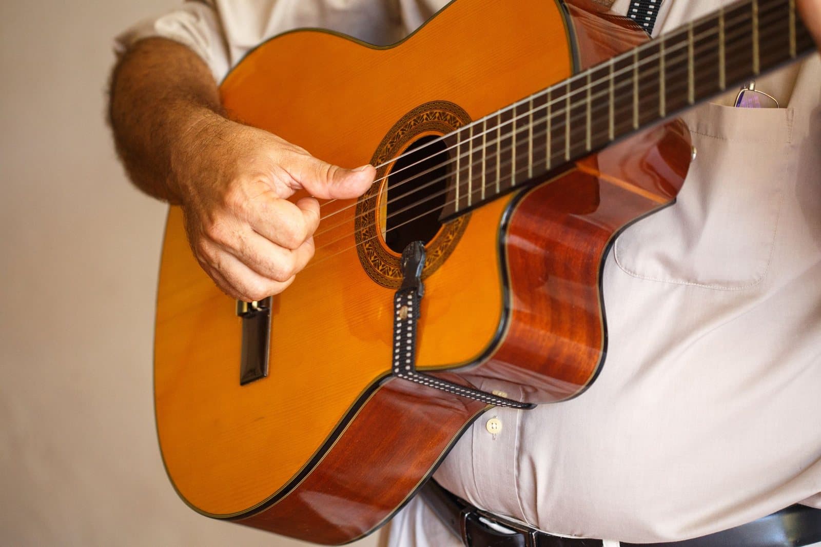 Die Hände eines Gitarristen auf den Saiten einer akustischen Gitarre