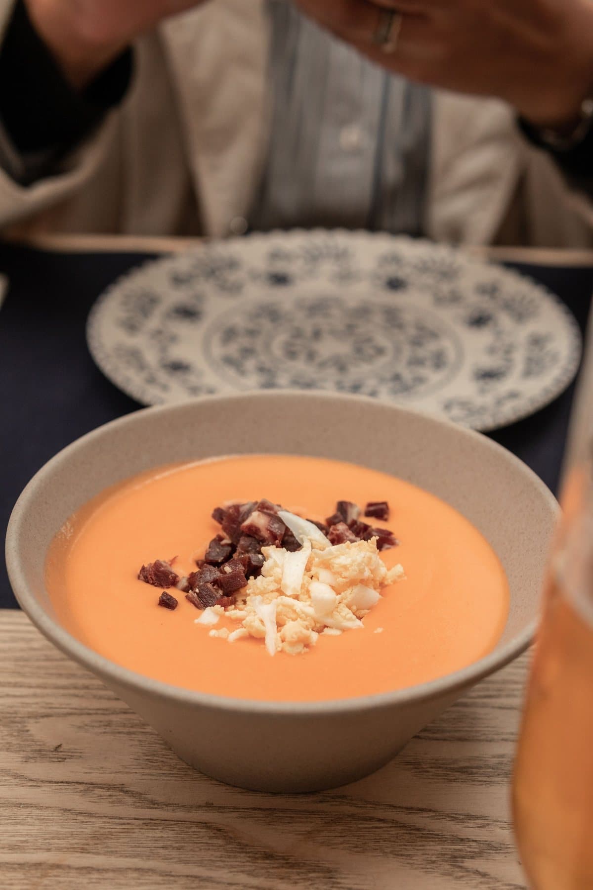 A bowl of salmorejo topped with ham and egg