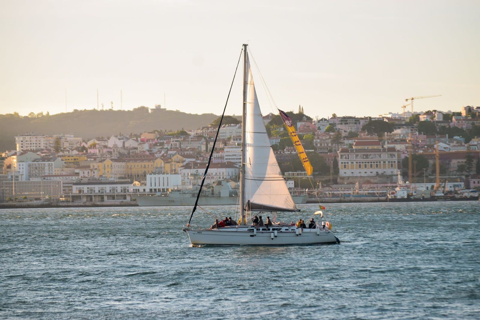 A sailboat on the Tagus with Lisbon's waterfront behind