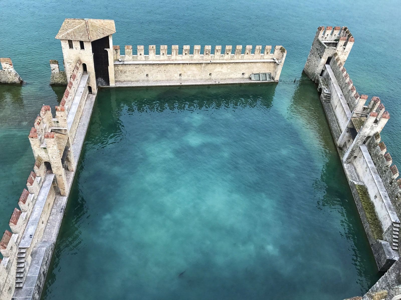 Walls of Scaliger Castle and clear water in Sirmione