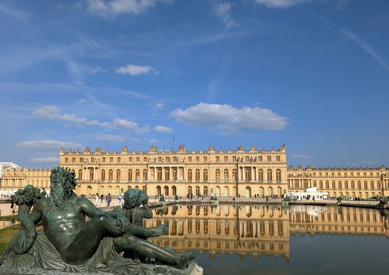 El Palacio de Versalles visto desde el Parterre de Agua, con una estatua fluvial de bronce