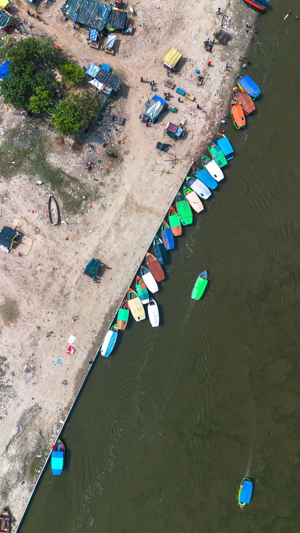 Colourful boats lined up on the Yamuna riverbank at Vrindavan, from above