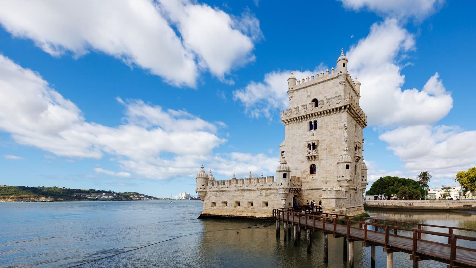 Belém Tower on the Tagus under a blue sky, with the walkway to its entrance