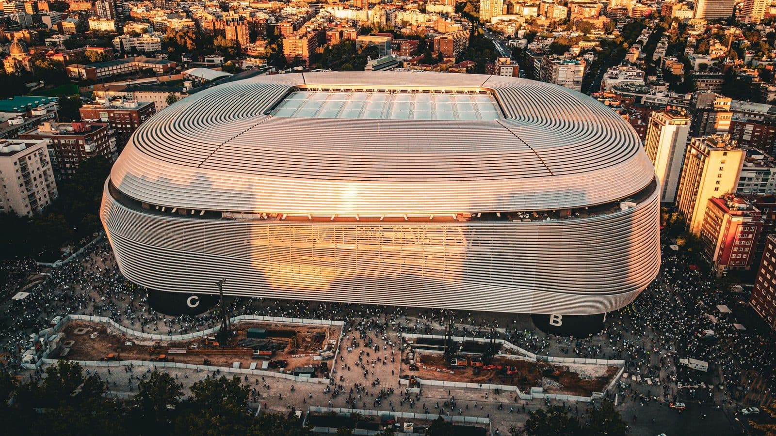 Santiago Bernabéu Stadium from above at sunset, with crowds outside