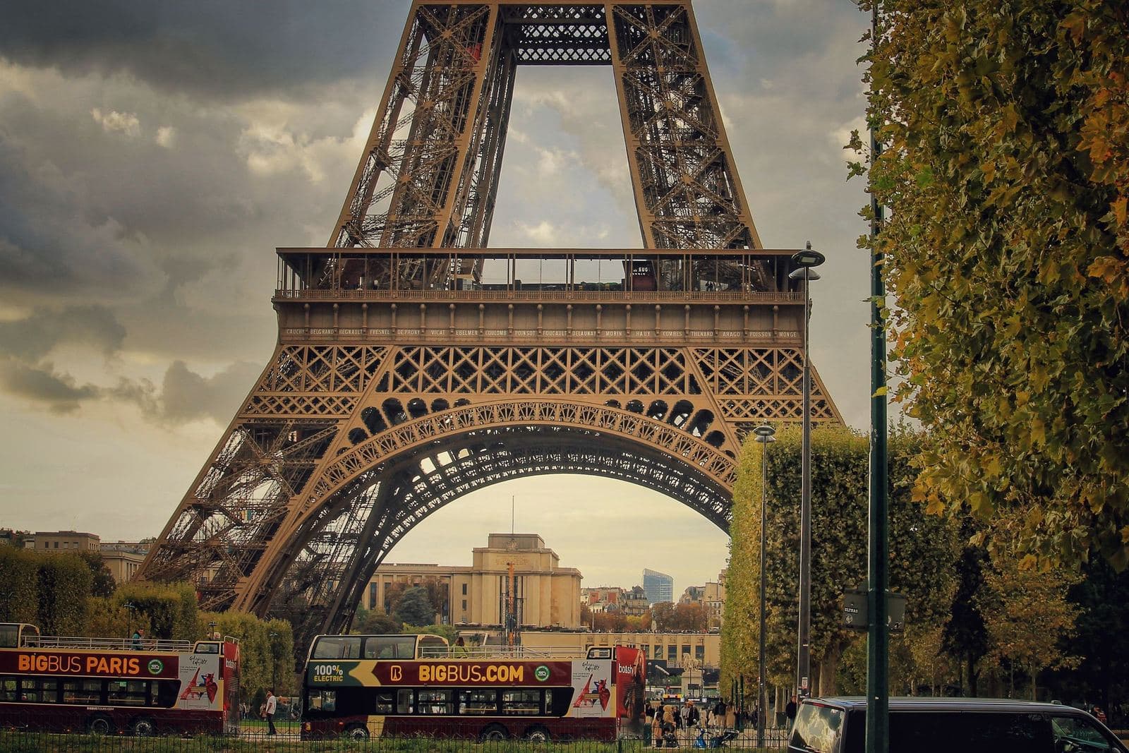Eiffel Tower framed by trees, a stop on the hop-on hop-off route