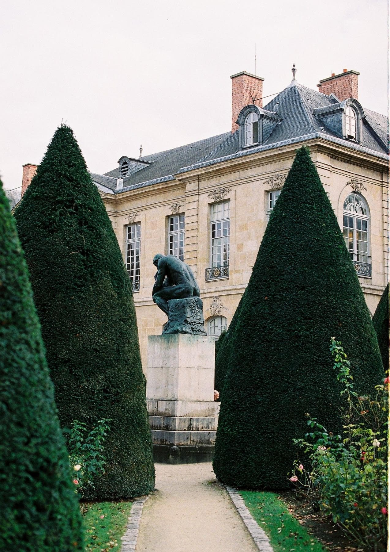 Hôtel Biron, home of the Musée Rodin, with clipped yews and a bronze in the garden